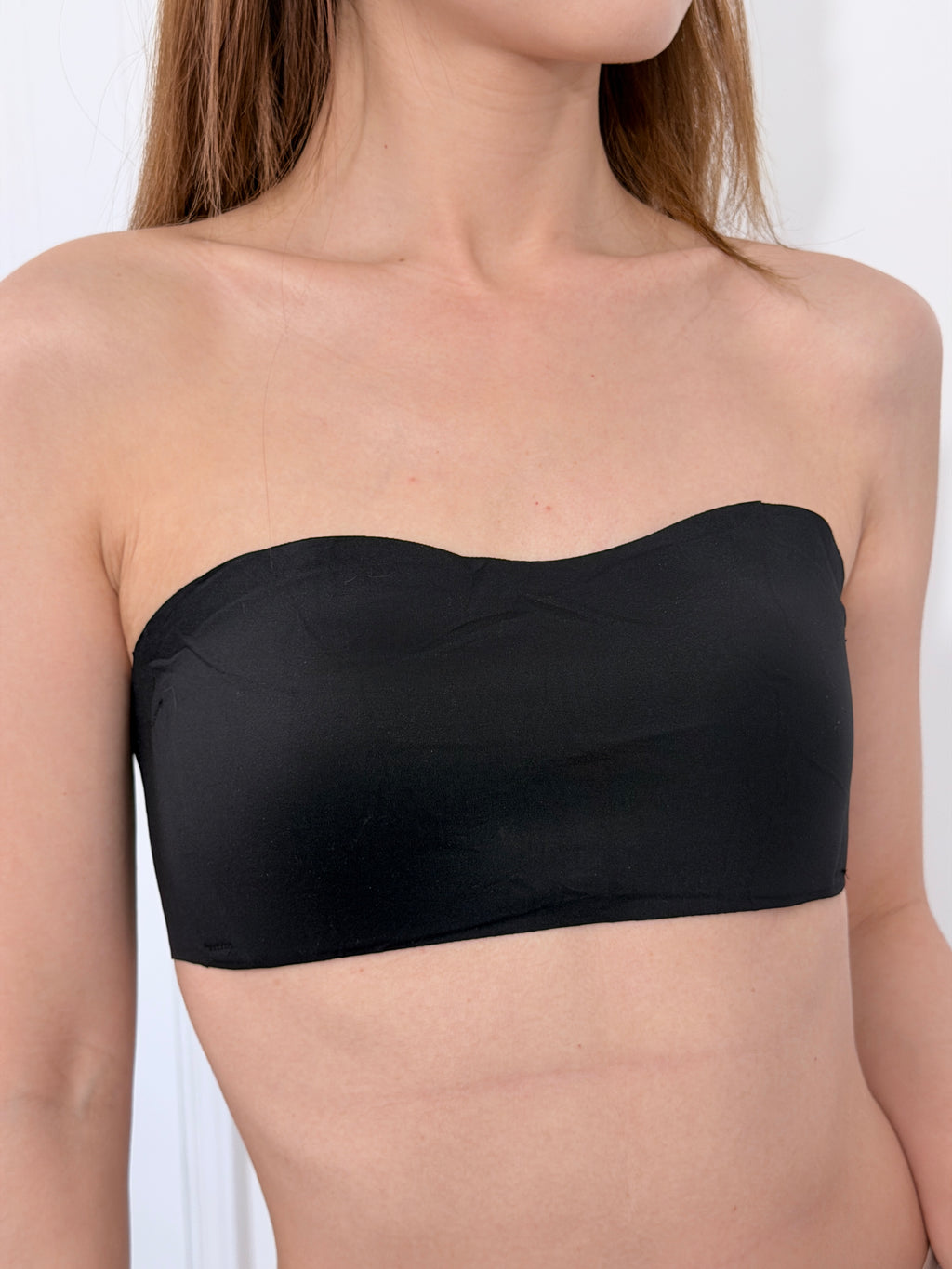 Flaty black strapless bra side view showing flat chest fit for small busts