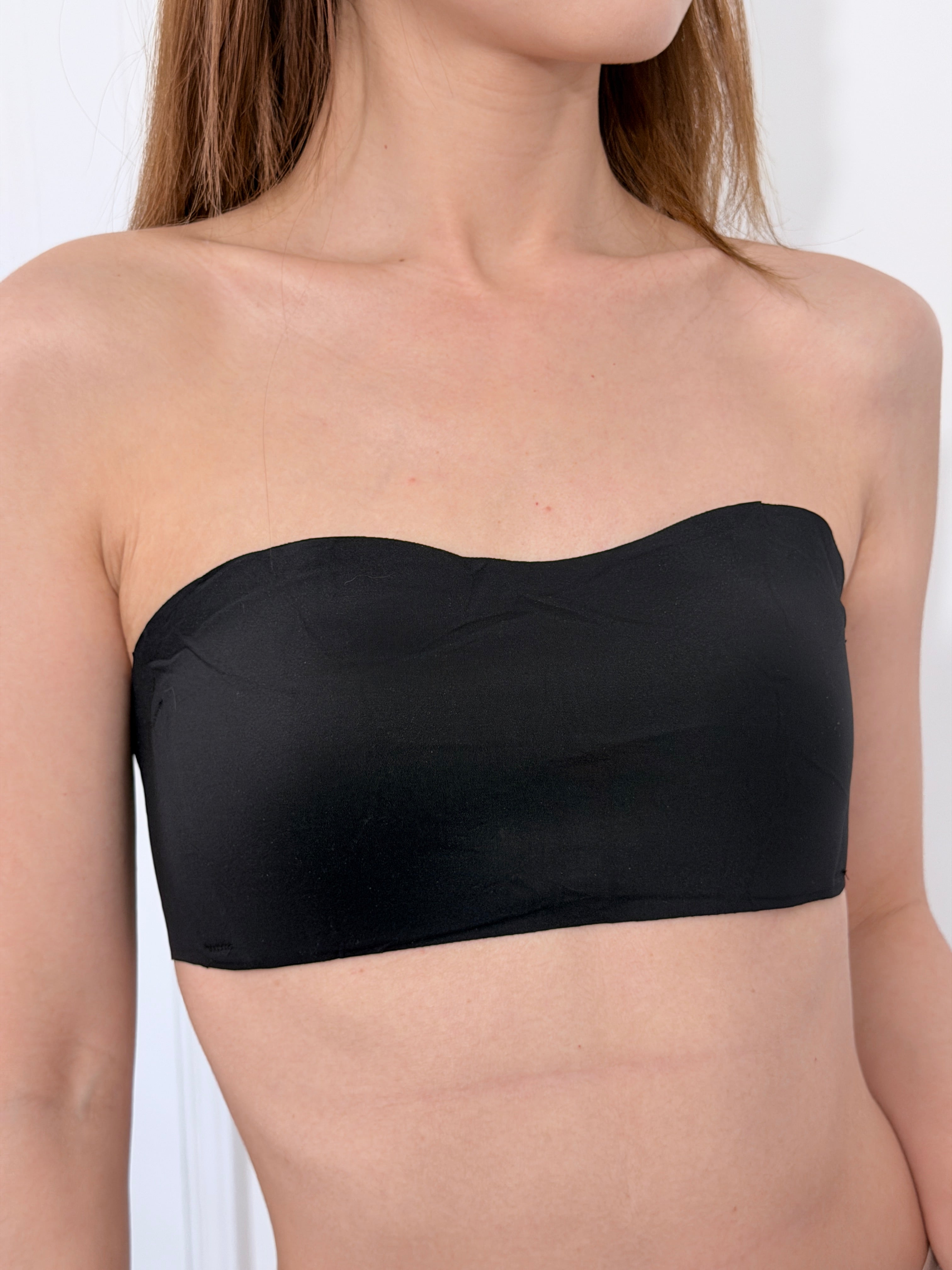 Flaty black strapless bra side view showing flat chest fit for small busts